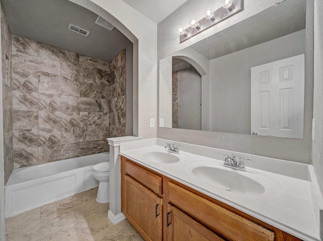 full bathroom featuring vanity, toilet, and tiled shower / bath