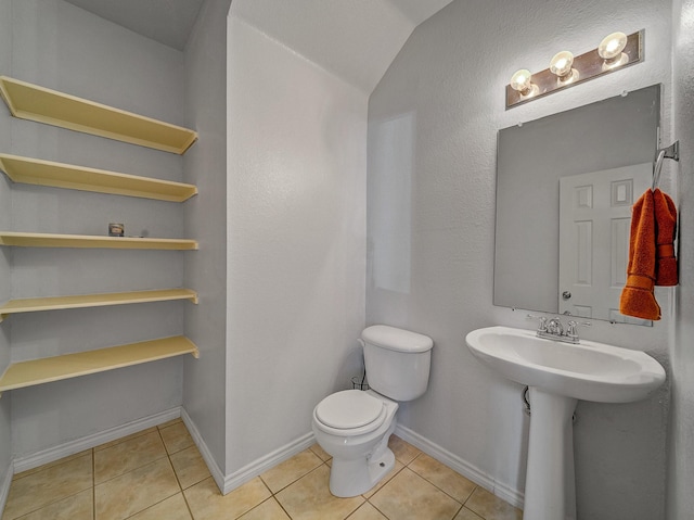 bathroom with tile patterned flooring, lofted ceiling, and toilet