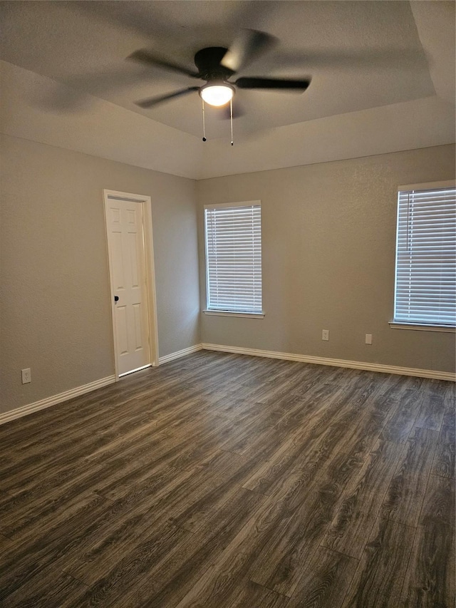 empty room featuring dark hardwood / wood-style floors, a healthy amount of sunlight, and ceiling fan