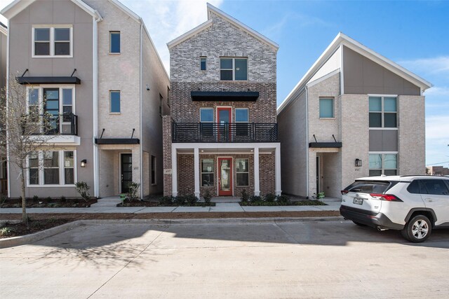 view of front of home with a balcony and a front yard