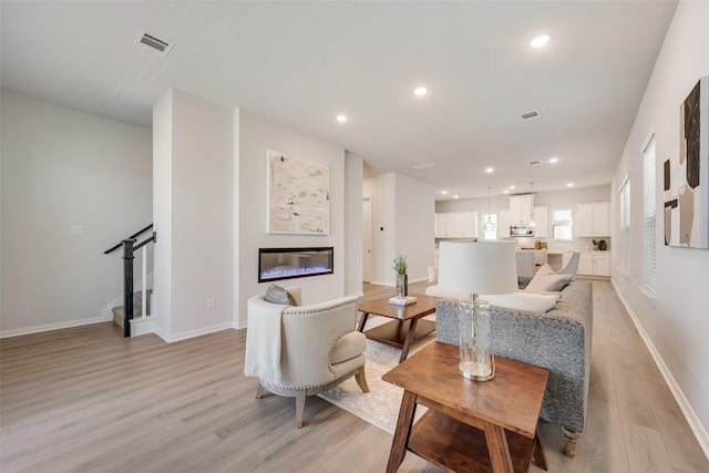 4557 Ward St, North Richland Hills, TX 76180 - living area with recessed lighting, visible vents, a glass covered fireplace, and light wood-style floors