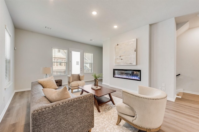4557 Ward St, North Richland Hills, TX 76180 - living room with baseboards, recessed lighting, light wood-style floors, and a glass covered fireplace
