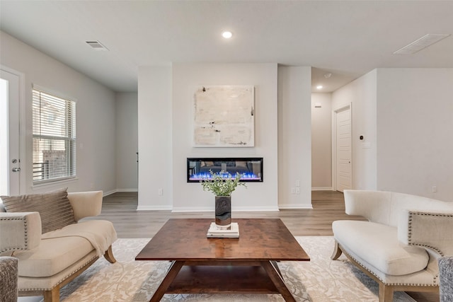 4557 Ward St, North Richland Hills, TX 76180 - living area with light wood finished floors, visible vents, recessed lighting, and a glass covered fireplace