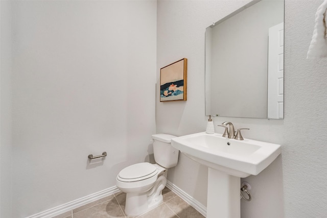 4557 Ward St, North Richland Hills, TX 76180 - bathroom featuring baseboards, toilet, tile patterned flooring, and a sink