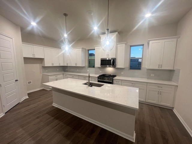 kitchen featuring white cabinets, appliances with stainless steel finishes, decorative light fixtures, and sink