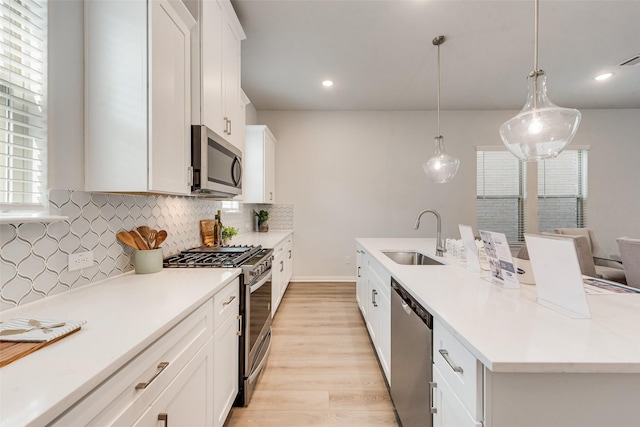 4557 Ward St, North Richland Hills, TX 76180 - kitchen featuring light wood-type flooring, stainless steel appliances, backsplash, a sink, and an island with sink
