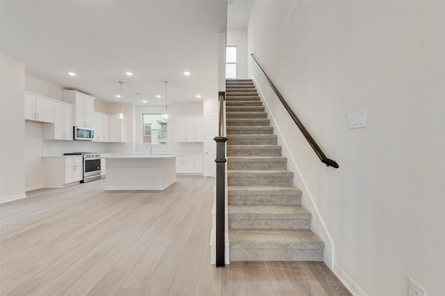 staircase featuring plenty of natural light and hardwood / wood-style floors