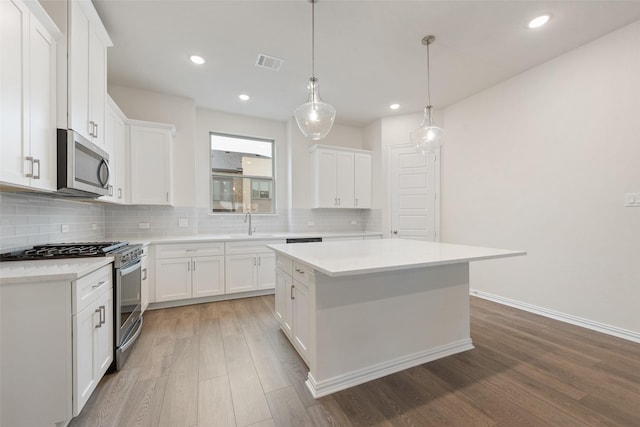 kitchen with white cabinetry, stainless steel appliances, and a center island