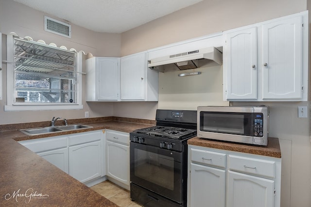 kitchen with white cabinets, black gas range, premium range hood, and sink