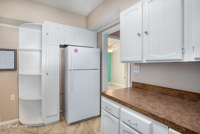 kitchen with white cabinetry, white fridge, light tile patterned floors, and ceiling fan