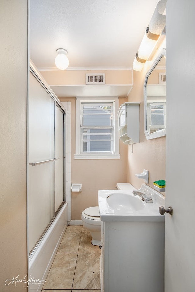 full bathroom featuring toilet, crown molding, shower / bath combination with glass door, vanity, and tile patterned flooring