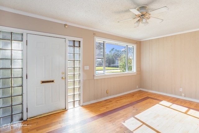 entryway featuring ornamental molding, hardwood / wood-style floors, ceiling fan, and a textured ceiling