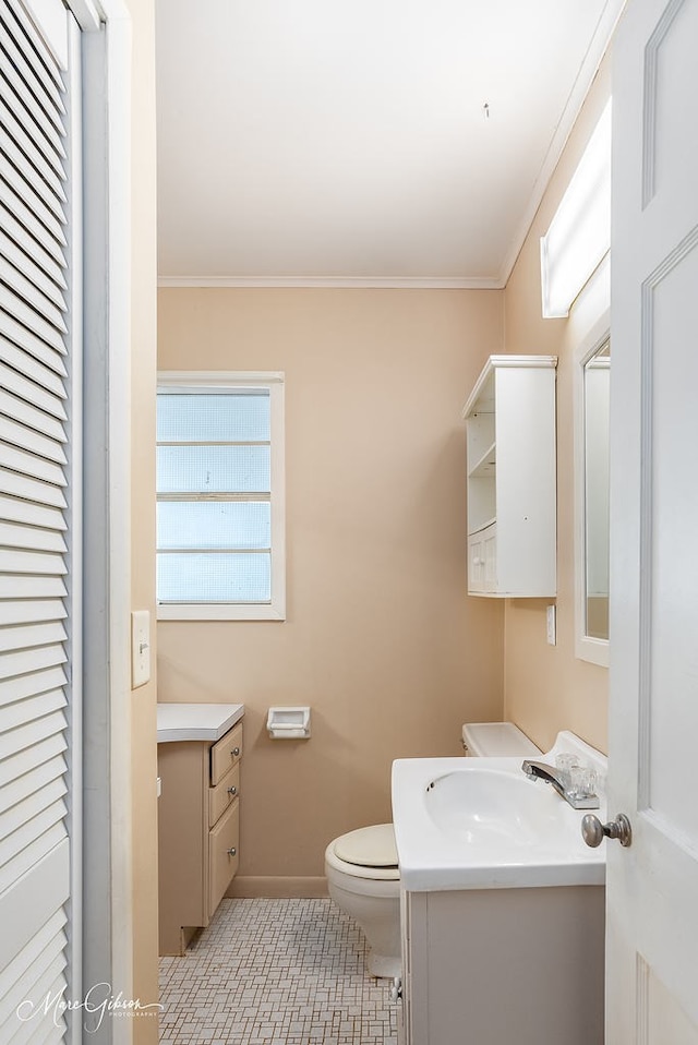 bathroom with vanity, tile patterned flooring, crown molding, and toilet