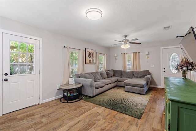 living room featuring light hardwood / wood-style flooring and ceiling fan