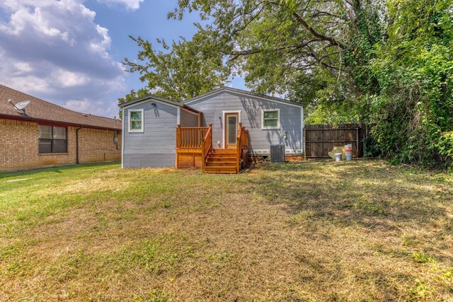 view of front of property featuring central AC, a front yard, and a deck