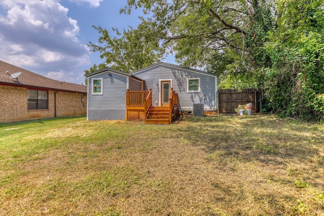 view of front of home with central AC, a deck, and a front lawn