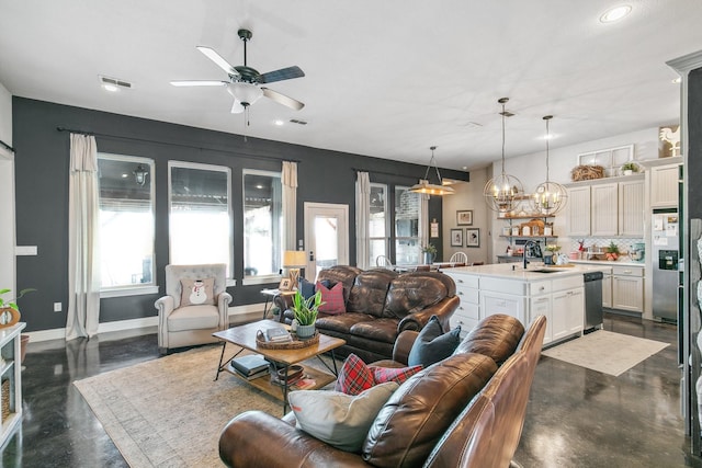 living room with ceiling fan with notable chandelier and sink