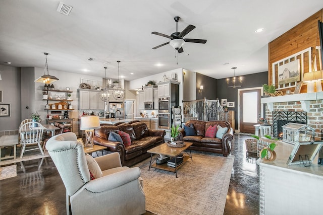 living room featuring a fireplace and ceiling fan with notable chandelier