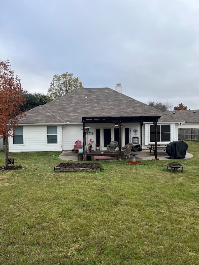 rear view of house with ceiling fan, a yard, and a patio