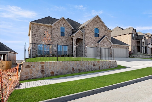 view of front facade featuring a fenced front yard, an attached garage, brick siding, concrete driveway, and a front lawn