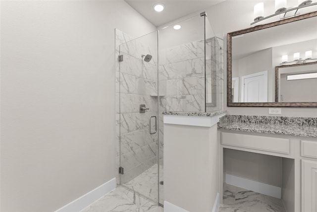 bathroom with marble finish floor, a marble finish shower, vanity, and baseboards