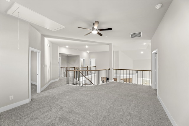 unfurnished room featuring attic access, carpet flooring, visible vents, and baseboards