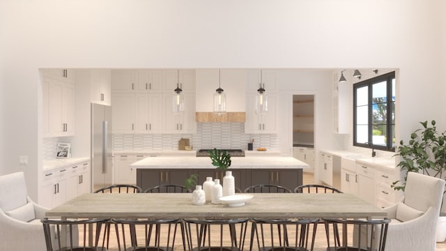 kitchen with white cabinetry, stainless steel fridge, and a kitchen island