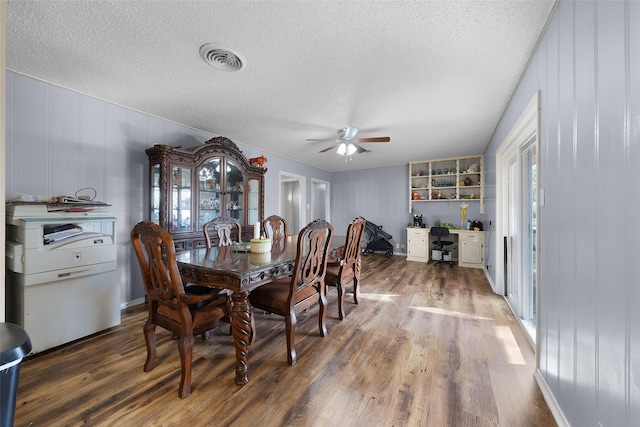 dining room with ceiling fan, a textured ceiling, and hardwood / wood-style flooring