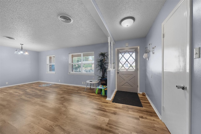 entrance foyer featuring hardwood / wood-style flooring and an inviting chandelier