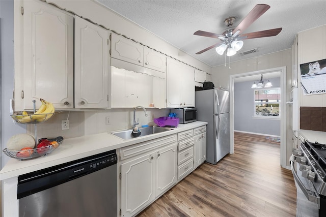 kitchen featuring white cabinets, sink, stainless steel appliances, and a textured ceiling