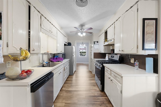 kitchen featuring appliances with stainless steel finishes, white cabinetry, and sink