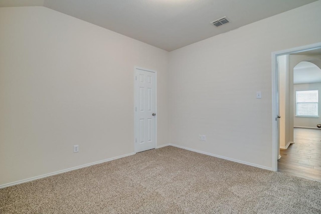 unfurnished room with carpet floors and lofted ceiling