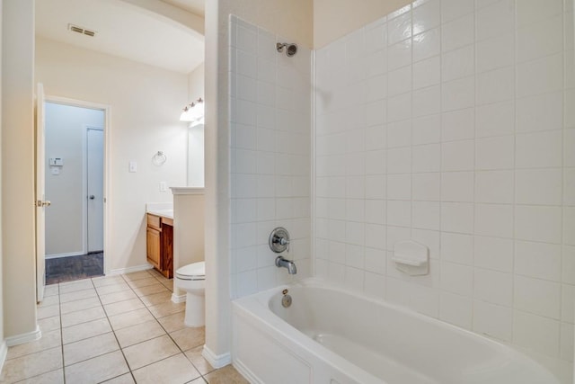 full bathroom featuring tile patterned flooring, vanity, tiled shower / bath combo, and toilet