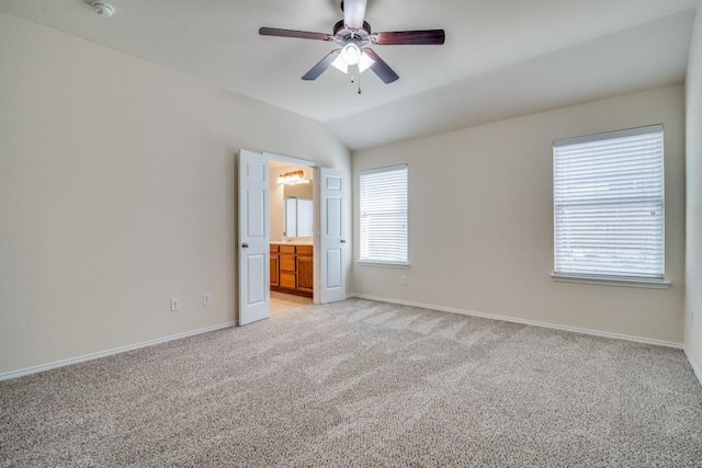 unfurnished bedroom with light carpet, connected bathroom, ceiling fan, and lofted ceiling