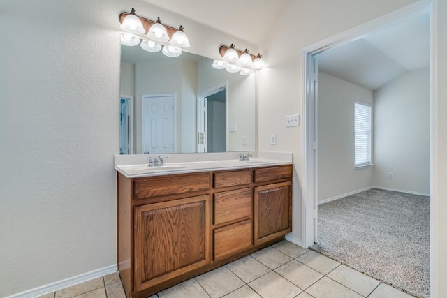 bathroom featuring tile patterned floors, vanity, and vaulted ceiling