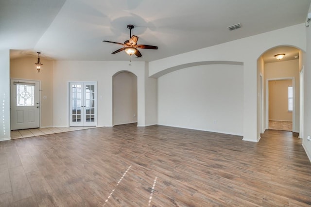 unfurnished living room with ceiling fan, lofted ceiling, french doors, and light hardwood / wood-style flooring