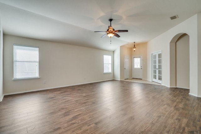 empty room featuring dark hardwood / wood-style floors, vaulted ceiling, and ceiling fan