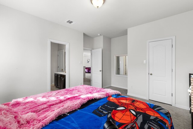 carpeted bedroom featuring ensuite bath