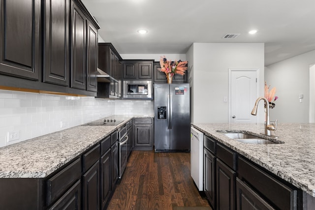 kitchen featuring sink, light stone countertops, tasteful backsplash, dark hardwood / wood-style flooring, and stainless steel appliances