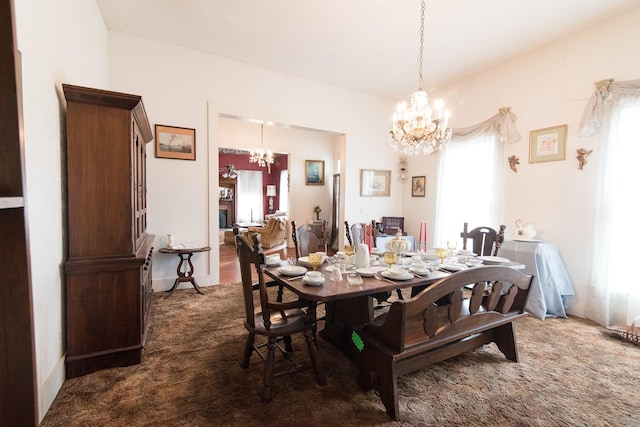 carpeted dining room with an inviting chandelier