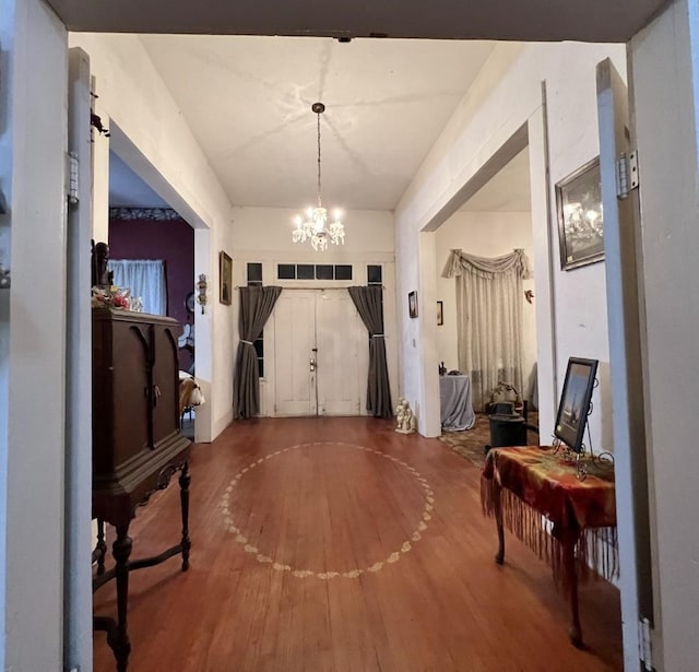 foyer entrance with wood-type flooring and a chandelier