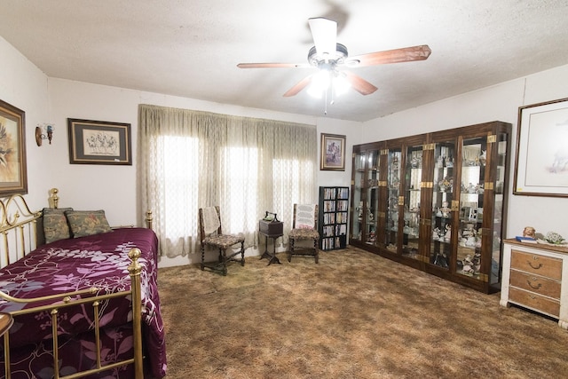 carpeted bedroom featuring ceiling fan and a textured ceiling