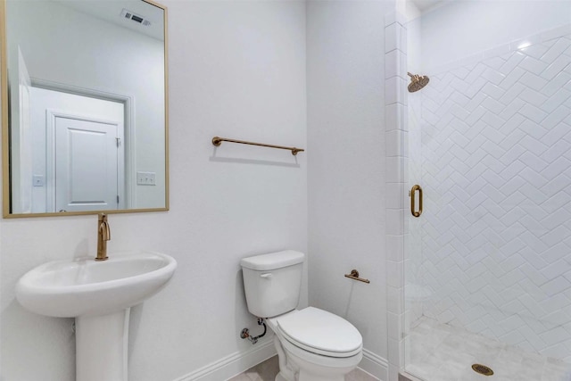 bathroom featuring toilet, a shower stall, visible vents, and baseboards