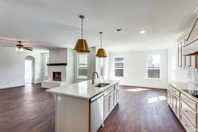 kitchen with a sink, visible vents, open floor plan, stainless steel dishwasher, and an island with sink