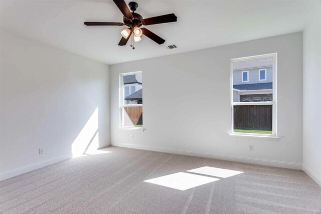 unfurnished room featuring light carpet, baseboards, visible vents, and a ceiling fan