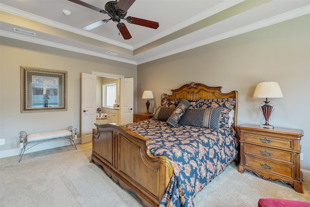 bedroom featuring ensuite bath, ornamental molding, a raised ceiling, and light carpet