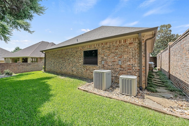 rear view of house featuring a yard and central AC