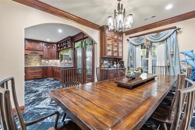 dining room featuring ornamental molding and a chandelier