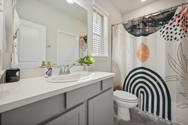 bathroom with a shower with curtain, vanity, and toilet