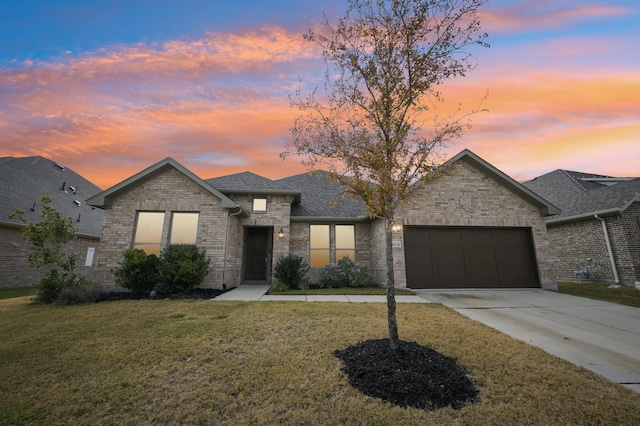 view of front of home featuring a garage and a lawn